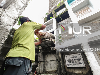 Erwin, in green, exhumes the remains buried inside the public cemetery in Antipolo City, Philippines, on October 31, 2024. A sack of human r...