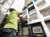 Erwin, in green, exhumes the remains buried inside the public cemetery in Antipolo City, Philippines, on October 31, 2024. A sack of human r...