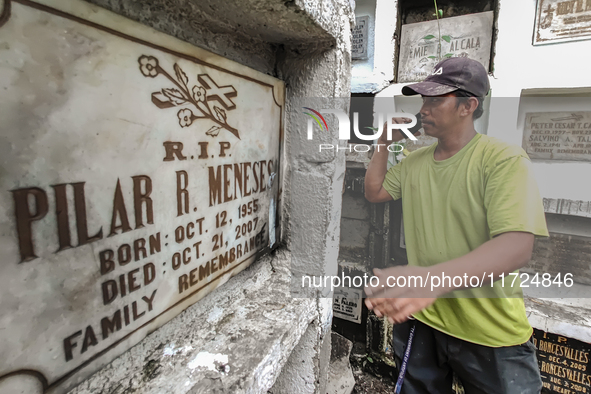 Erwin, in green, exhumes the remains buried inside the public cemetery in Antipolo City, Philippines, on October 31, 2024. A sack of human r...