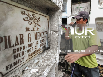 Erwin, in green, exhumes the remains buried inside the public cemetery in Antipolo City, Philippines, on October 31, 2024. A sack of human r...