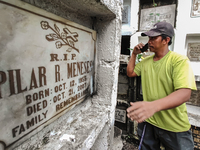 Erwin, in green, exhumes the remains buried inside the public cemetery in Antipolo City, Philippines, on October 31, 2024. A sack of human r...