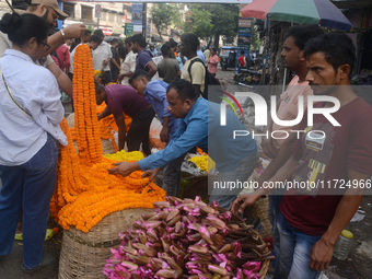 People buy flowers while sellers sell them at the roadside for home decorations on the occasion of 'Diwali', the Hindu festival of lights, i...