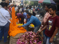 People buy flowers while sellers sell them at the roadside for home decorations on the occasion of 'Diwali', the Hindu festival of lights, i...