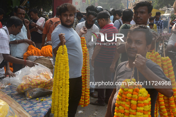 People buy flowers while sellers sell them at the roadside for home decorations on the occasion of 'Diwali', the Hindu festival of lights, i...