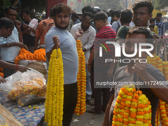 People buy flowers while sellers sell them at the roadside for home decorations on the occasion of 'Diwali', the Hindu festival of lights, i...