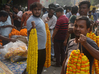 People buy flowers while sellers sell them at the roadside for home decorations on the occasion of 'Diwali', the Hindu festival of lights, i...