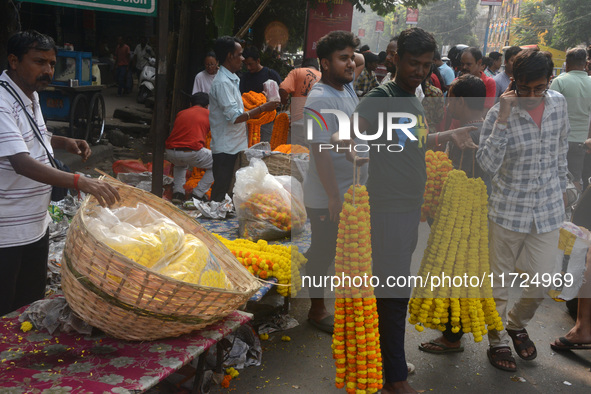 People buy flowers while sellers sell them at the roadside for home decorations on the occasion of 'Diwali', the Hindu festival of lights, i...