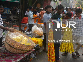 People buy flowers while sellers sell them at the roadside for home decorations on the occasion of 'Diwali', the Hindu festival of lights, i...