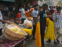 People buy flowers while sellers sell them at the roadside for home decorations on the occasion of 'Diwali', the Hindu festival of lights, i...