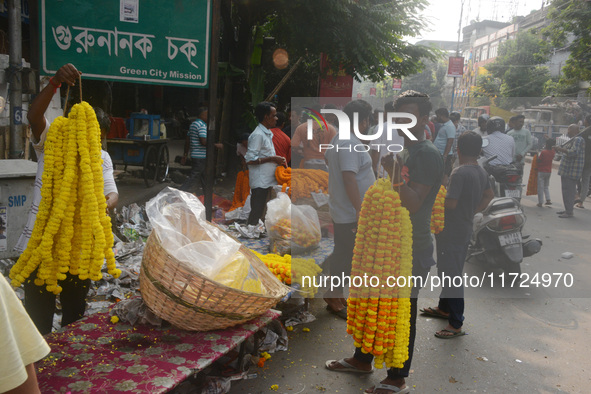 People buy flowers while sellers sell them at the roadside for home decorations on the occasion of 'Diwali', the Hindu festival of lights, i...