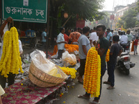 People buy flowers while sellers sell them at the roadside for home decorations on the occasion of 'Diwali', the Hindu festival of lights, i...