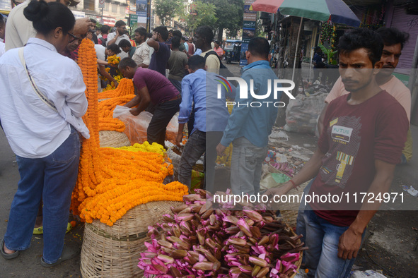 People buy flowers while sellers sell them at the roadside for home decorations on the occasion of 'Diwali', the Hindu festival of lights, i...