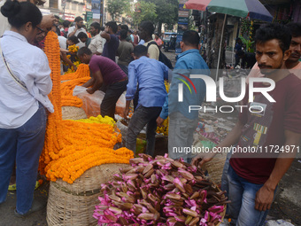 People buy flowers while sellers sell them at the roadside for home decorations on the occasion of 'Diwali', the Hindu festival of lights, i...