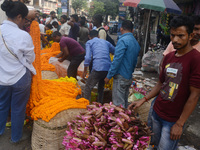 People buy flowers while sellers sell them at the roadside for home decorations on the occasion of 'Diwali', the Hindu festival of lights, i...