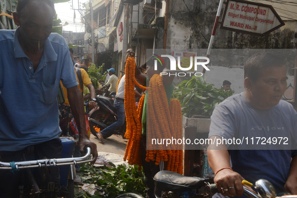 People buy flowers while sellers sell them at the roadside for home decorations on the occasion of 'Diwali', the Hindu festival of lights, i...