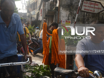 People buy flowers while sellers sell them at the roadside for home decorations on the occasion of 'Diwali', the Hindu festival of lights, i...