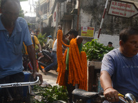 People buy flowers while sellers sell them at the roadside for home decorations on the occasion of 'Diwali', the Hindu festival of lights, i...