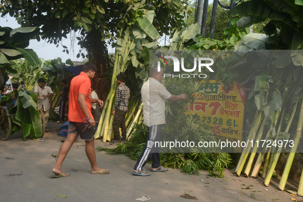 People buy banana trees while sellers sell them at the roadside for home decorations on the occasion of 'Diwali,' the Hindu festival of ligh...