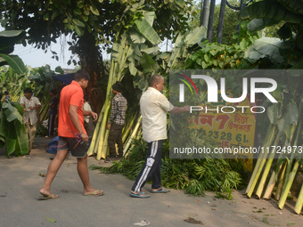 People buy banana trees while sellers sell them at the roadside for home decorations on the occasion of 'Diwali,' the Hindu festival of ligh...