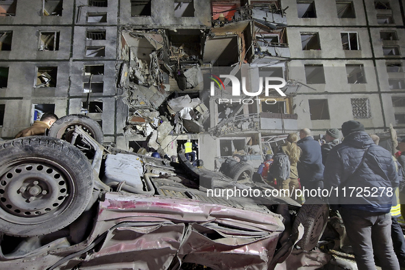 An overturned car is outside a section of a nine-storey residential building destroyed by a Russian glide bomb in Kharkiv, Ukraine, on Octob...