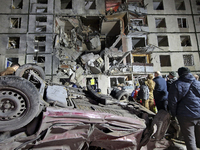 An overturned car is outside a section of a nine-storey residential building destroyed by a Russian glide bomb in Kharkiv, Ukraine, on Octob...