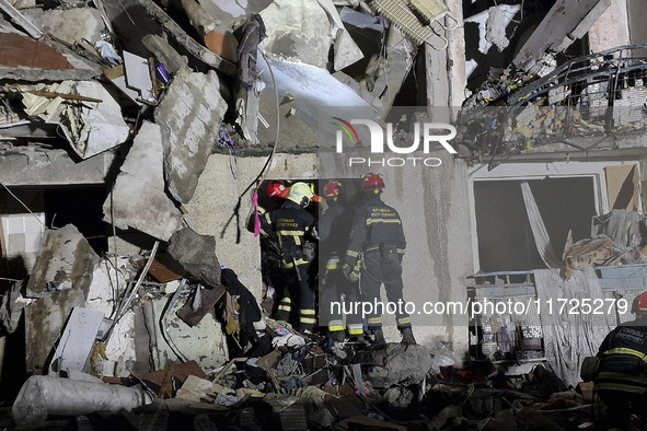 Rescuers work at a section of a nine-storey residential building destroyed by a Russian glide bomb in Kharkiv, Ukraine, on October 31, 2024....