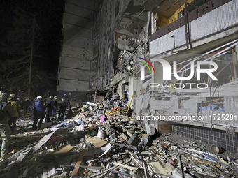 A search and rescue effort takes place outside a section of a nine-storey residential building destroyed by a Russian glide bomb in Kharkiv,...