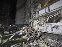 A search and rescue effort takes place outside a section of a nine-storey residential building destroyed by a Russian glide bomb in Kharkiv,...