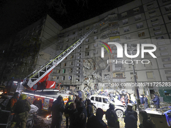 A search and rescue effort takes place outside a section of a nine-storey residential building destroyed by a Russian glide bomb in Kharkiv,...