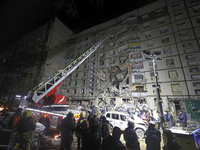 A search and rescue effort takes place outside a section of a nine-storey residential building destroyed by a Russian glide bomb in Kharkiv,...