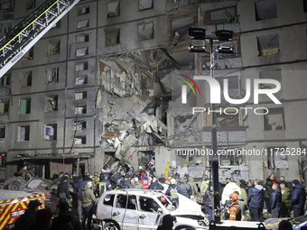 A search and rescue effort takes place outside a section of a nine-storey residential building destroyed by a Russian glide bomb in Kharkiv,...