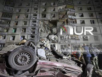 An overturned car is outside a section of a nine-storey residential building destroyed by a Russian glide bomb in Kharkiv, Ukraine, on Octob...