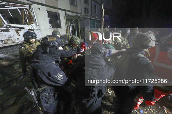 Rescuers and police officers carry an injured person at a section of a nine-storey residential building destroyed by a Russian glide bomb in...