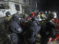 Rescuers and police officers carry an injured person at a section of a nine-storey residential building destroyed by a Russian glide bomb in...