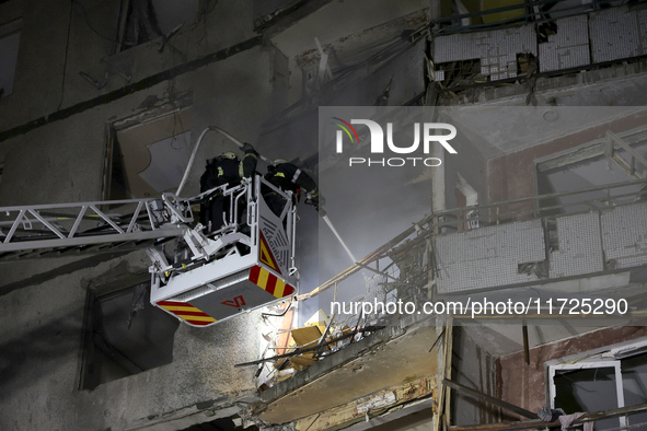 Rescuers use an aerial ladder to put out a fire in a nine-storey residential building damaged by a Russian glide bomb in Kharkiv, Ukraine, o...