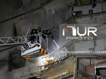 Rescuers use an aerial ladder to put out a fire in a nine-storey residential building damaged by a Russian glide bomb in Kharkiv, Ukraine, o...