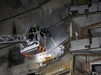 Rescuers use an aerial ladder to put out a fire in a nine-storey residential building damaged by a Russian glide bomb in Kharkiv, Ukraine, o...