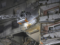 Rescuers use an aerial ladder to put out a fire in a nine-storey residential building damaged by a Russian glide bomb in Kharkiv, Ukraine, o...