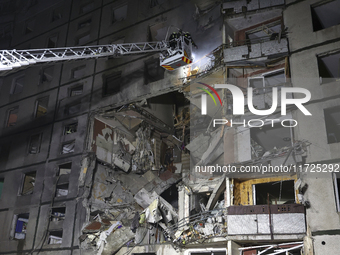 Rescuers use an aerial ladder to put out a fire in a nine-storey residential building damaged by a Russian glide bomb in Kharkiv, Ukraine, o...