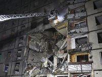 Rescuers use an aerial ladder to put out a fire in a nine-storey residential building damaged by a Russian glide bomb in Kharkiv, Ukraine, o...