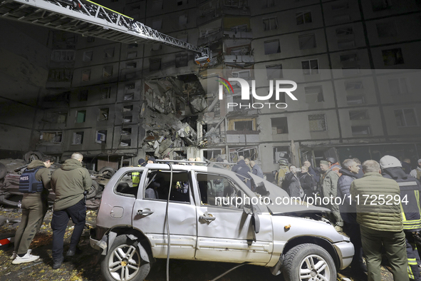 Rescuers use an aerial ladder to reach the affected floors of a nine-storey residential building damaged by a Russian glide bomb in Kharkiv,...