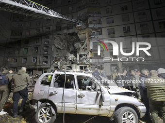 Rescuers use an aerial ladder to reach the affected floors of a nine-storey residential building damaged by a Russian glide bomb in Kharkiv,...