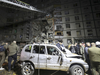 Rescuers use an aerial ladder to reach the affected floors of a nine-storey residential building damaged by a Russian glide bomb in Kharkiv,...