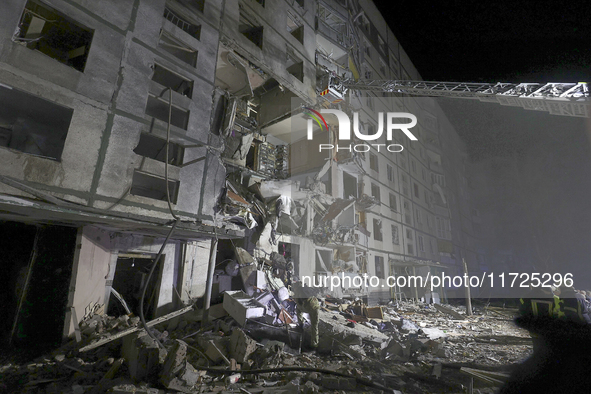 Rescuers use an aerial ladder to reach the affected floors of a nine-storey residential building damaged by a Russian glide bomb in Kharkiv,...