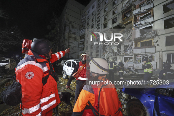 Paramedics stand outside a section of a nine-storey residential building destroyed by a Russian glide bomb in Kharkiv, Ukraine, on October 3...