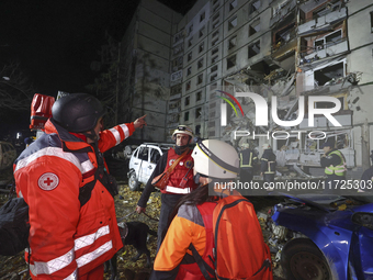 Paramedics stand outside a section of a nine-storey residential building destroyed by a Russian glide bomb in Kharkiv, Ukraine, on October 3...