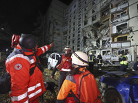 Paramedics stand outside a section of a nine-storey residential building destroyed by a Russian glide bomb in Kharkiv, Ukraine, on October 3...