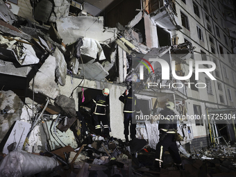 Rescuers work at a section of a nine-storey residential building destroyed by a Russian glide bomb in Kharkiv, Ukraine, on October 31, 2024....