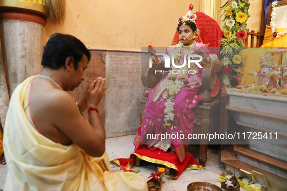 A Hindu priest offers prayer to Ridhima Jana, a 9-year-old girl dressed as a Kumari, who is worshiped by devotees during rituals to celebrat...