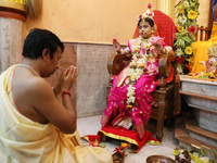 A Hindu priest offers prayer to Ridhima Jana, a 9-year-old girl dressed as a Kumari, who is worshiped by devotees during rituals to celebrat...